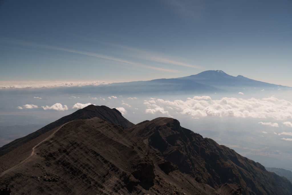 Mount Meru summit reflected in Momella Lakes with flamingos in foreground at Arusha National Park Tanzania