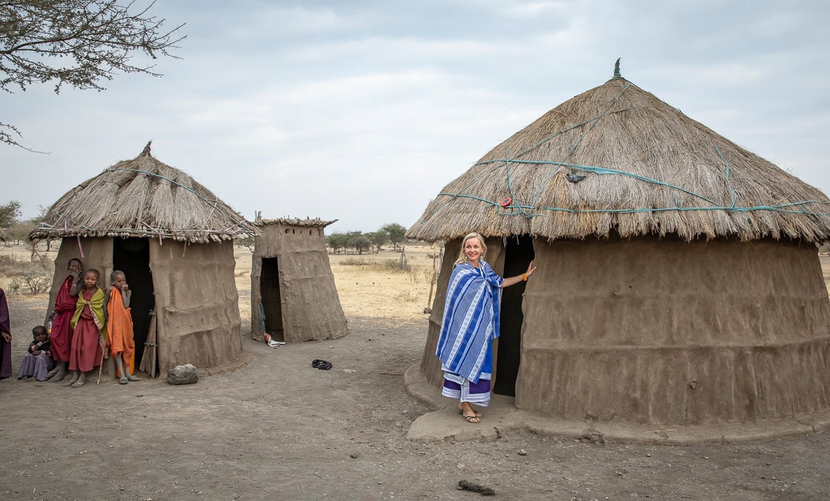 A visitor in cultural bomas with children