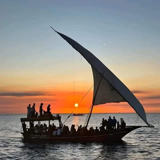 Traditional Lamu dhow sailing at sunset with full lateen sail